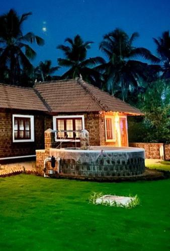 a small house with a green lawn in front of it at Coastal Stay with private Beach Access KAPU in Udiyāvara