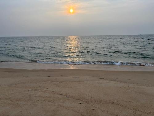 a beach with the sun rising over the ocean at Coastal Stay with private Beach Access KAPU in Udiyāvara