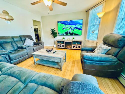 a living room with couches and a flat screen tv at Bright, Stylish & Cozy 2Bed Unit w/Backyard & Grill Close to NYC! in Haledon