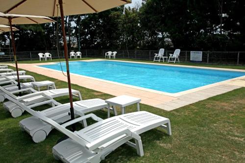 a group of lounge chairs and a swimming pool at Awaji International Hotel The Sunplaza in Sumoto