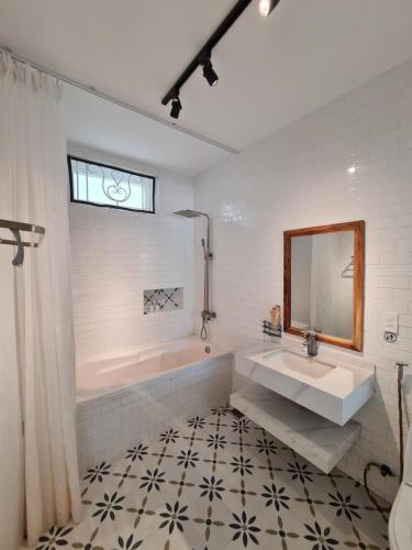 a bathroom with a sink and a tub and a mirror at Myhoa Lagoon - Kiting Town in Phan Rang