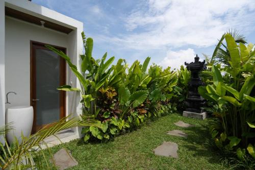 a garden of plants next to a building at Oemah Manureva Ubud in Mambat