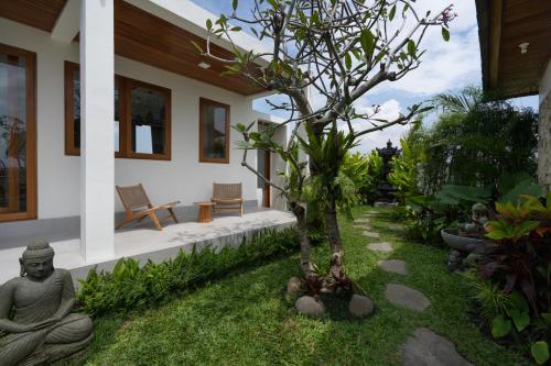 a house with a meditation yard with a tree at Oemah Manureva Ubud in Mambat