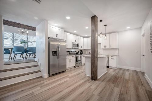 una grande cucina con mobili bianchi e sedie blu di 701 W Indiana Ave a Tampa