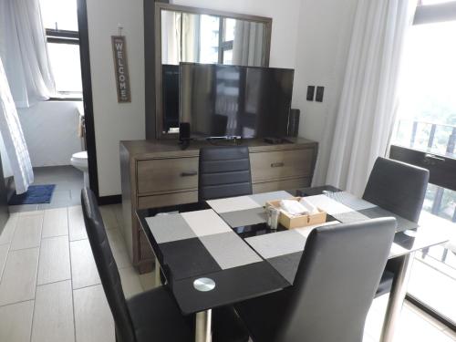 a dining room with a table and a television at Loft urbano, Ciudad Guatemala, EON in Estación Pamplona