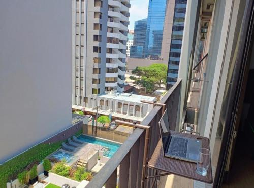 a laptop on a balcony with a view of a building at Loft urbano, Ciudad Guatemala, EON in Estación Pamplona
