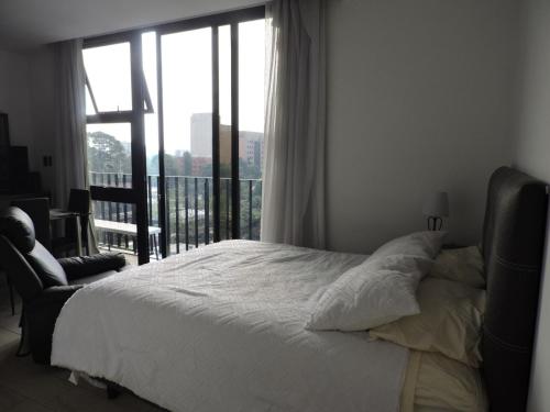 a bedroom with a bed and a large window at Loft urbano, Ciudad Guatemala, EON in Estación Pamplona