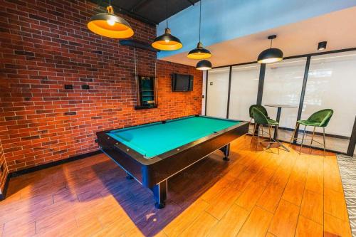 a pool table in a room with a brick wall at Loft urbano, Ciudad Guatemala, EON in Estación Pamplona