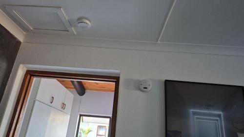 a room with a ceiling with a mirror and a window at At lilac, Jeffreys Bay, cottage for 2 in Jeffreys Bay