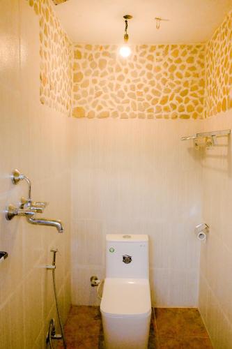 a bathroom with a toilet and a shower at Barang Village Community Homestay in Pokhara