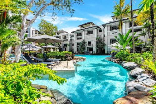 una imagen de una piscina en un resort en Elysium Private Apartments Triton by the Sea, en Palm Cove