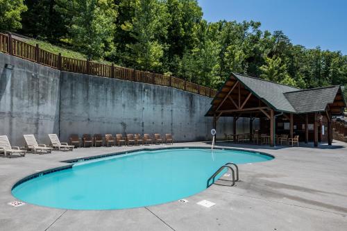 a large swimming pool with a gazebo and chairs at The Bear Club in Pigeon Forge