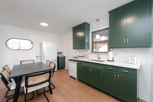 a kitchen with green cabinets and a table with chairs at Lake Hickory Trio 2BR Green Unit in Hickory