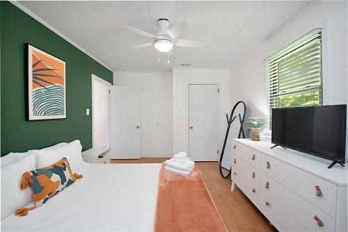 a bedroom with a white bed and a flat screen tv at Lake Hickory Trio 2BR Green Unit in Hickory