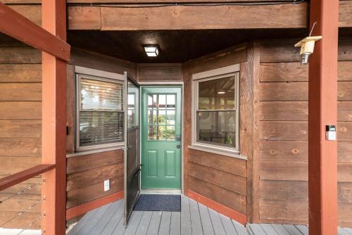 a wooden building with a green door and two windows at Lake Hickory Trio 2BR Green Unit in Hickory