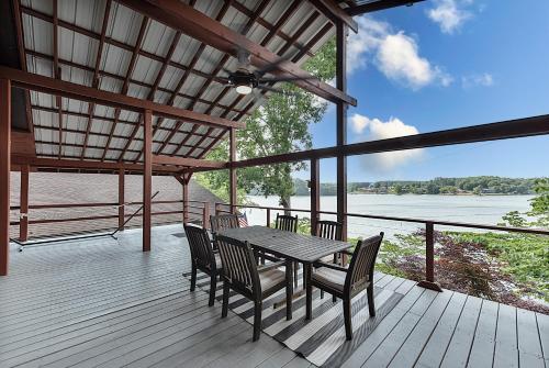 a table and chairs on a deck with a view of the water at Lake Hickory Trio 2BR Green Unit in Hickory