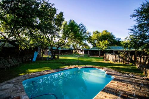 una piscina en un patio con una casa en Hoeksfontein game lodge, en Pearston