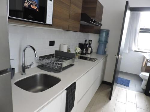a kitchen counter with a sink and a microwave at Loft urbano, Ciudad Guatemala, EON in Estación Pamplona