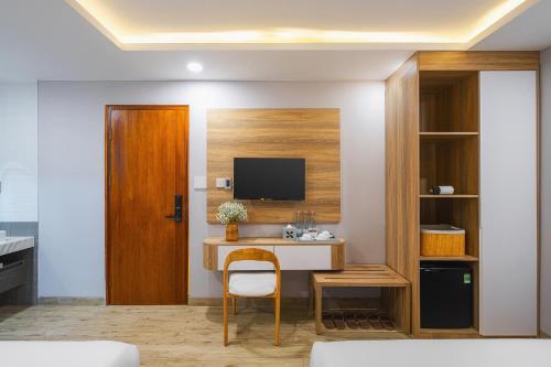 a room with a desk and a tv on a wall at Nature Hotel - Win Happy in Da Lat