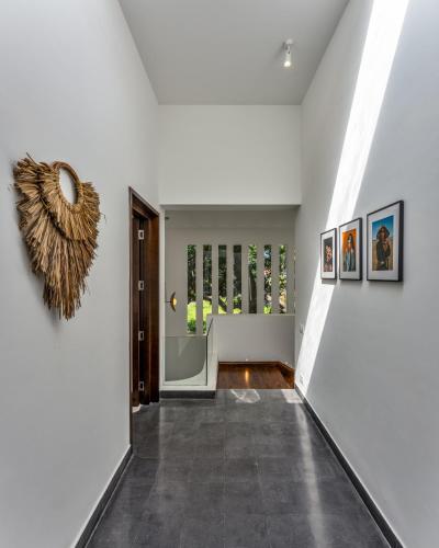 a hallway with white walls and a wreath on the wall at La Masillia, 2 BHK with Private Pool, 15 mins from Morjim Beach, Wifi, Peaceful location, Kitchen, Security, Patio in Siolim