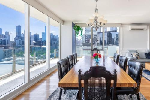 a dining room with a table and chairs and large windows at Views for Days - Luxe 4BR Stay with Pool & Hot Tub in Melbourne