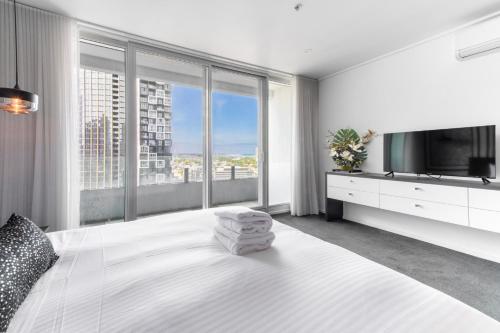 a bedroom with a large bed with a large window at Views for Days - Luxe 4BR Stay with Pool & Hot Tub in Melbourne