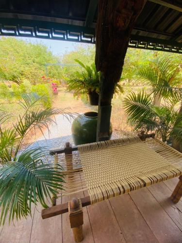 a wooden bench sitting on a patio with plants at Mintys Folly 2 in Ban Man
