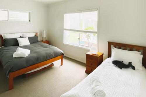 une chambre avec un chat noir allongé sur un lit dans l'établissement Seabreeze at One Mile, à Boat Harbour