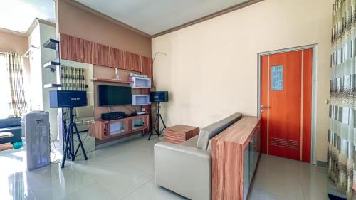 a living room with a couch and a red door at SpringHills Villa Panderman Batu - Private Pool in Tlekung