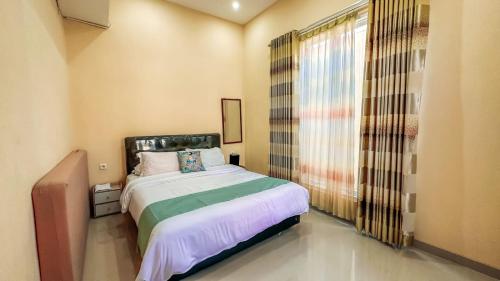 a bedroom with a bed and a large window at SpringHills Villa Panderman Batu - Private Pool in Tlekung