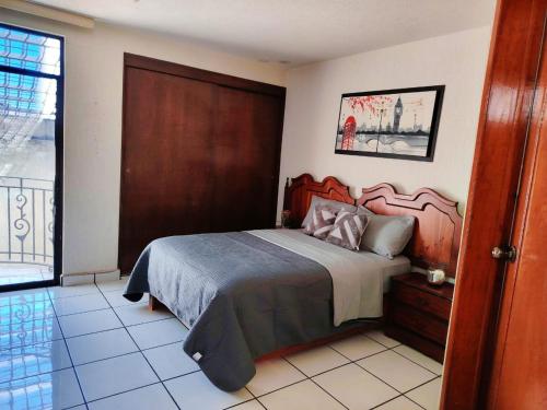 a bedroom with a bed with a wooden headboard at Casa Luna in Morelia
