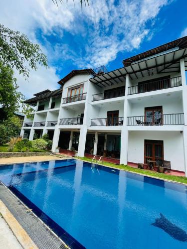 a hotel with a swimming pool in front of a building at Amelia Resort in Sigiriya