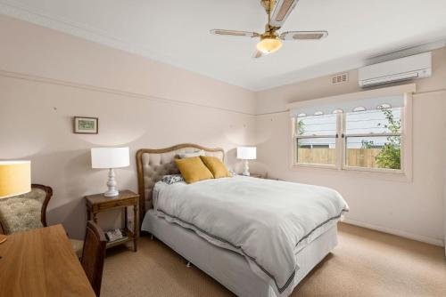 a bedroom with a bed and a table and a window at Glendarra in Point Lonsdale