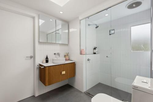 a bathroom with a glass shower and a sink at Glendarra in Point Lonsdale
