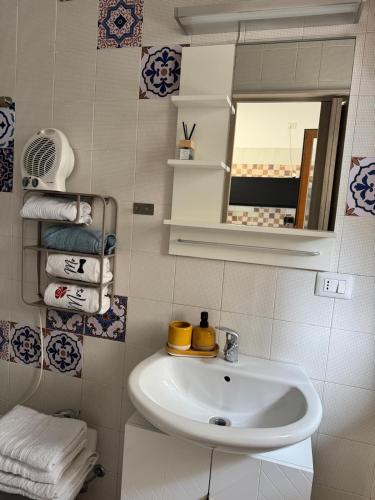 a bathroom with a sink and a mirror and towels at Casa AZZURRA in Giovinazzo