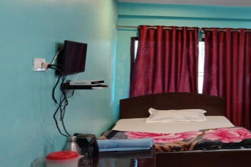 a bedroom with a bed with a television and a window at HIll Queen Homestay Chaukori By StayApart in Chaukori