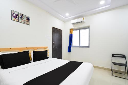 a bedroom with a black and white bed and a window at Super Collection O Adibatla Hyderabad in Ibrāhīmpatan