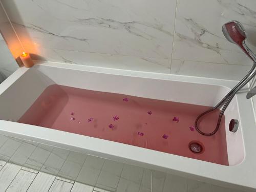 a pink bath tub with pink flowers in it at Mafruma in H̱adera