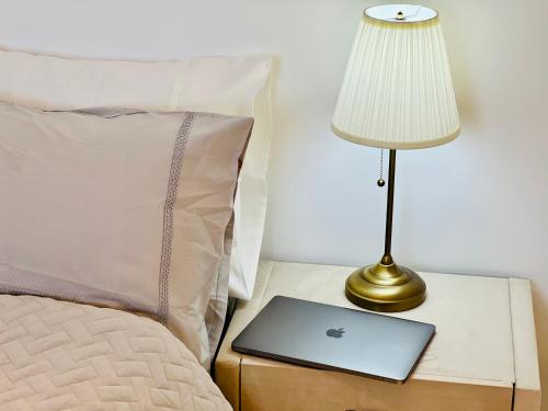 a table with a lamp and a laptop on a bed at Mafruma in H̱adera