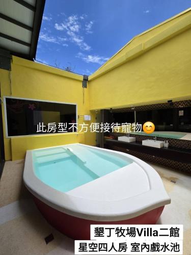 a bath tub sitting in front of a building at 墾丁牧場Villa Kenting Pasture - Villa B&B in Kenting