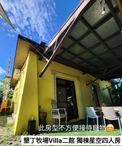 awning on the side of a house with chairs at 墾丁牧場Villa Kenting Pasture - Villa B&B in Kenting