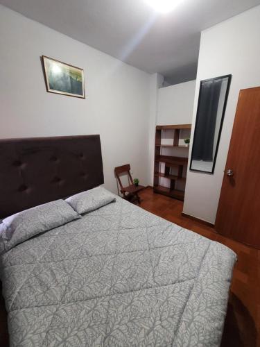 a bedroom with a bed and a chair in it at GoodWaves Hostel in Huanchaco