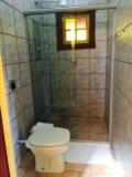 a bathroom with a toilet and a shower at Pousada Recanto Das Pedras in Tiradentes