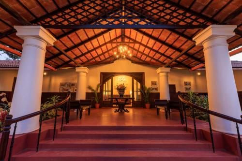 a large lobby with a wooden ceiling and stairs at The Hallery By Old Kent in Madikeri