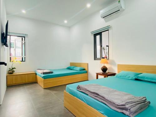 a bedroom with two beds and two windows at Green Homestay Tuy Hòa in Liên Trì (4)