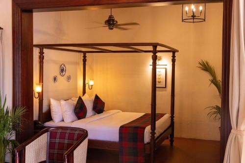 a bedroom with a canopy bed in a room at The Hallery By Old Kent in Madikeri