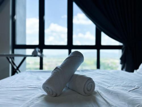 a roll of toilet paper sitting on top of a bed at Tulip Residences by Manhattan Group in Shah Alam