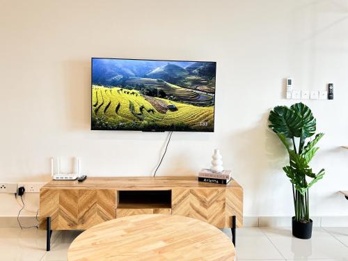 a tv hanging on a wall above a wooden desk at Tulip Residences by Manhattan Group in Shah Alam