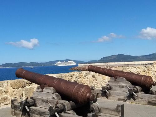 a pair of cannons sitting on the side of the ocean at Sardinia rooms in Alghero