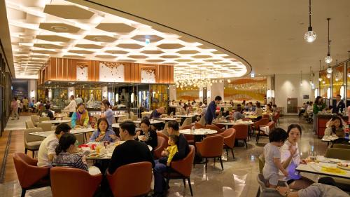 a group of people sitting at tables in a restaurant at Grand Hyatt Jeju in Jeju